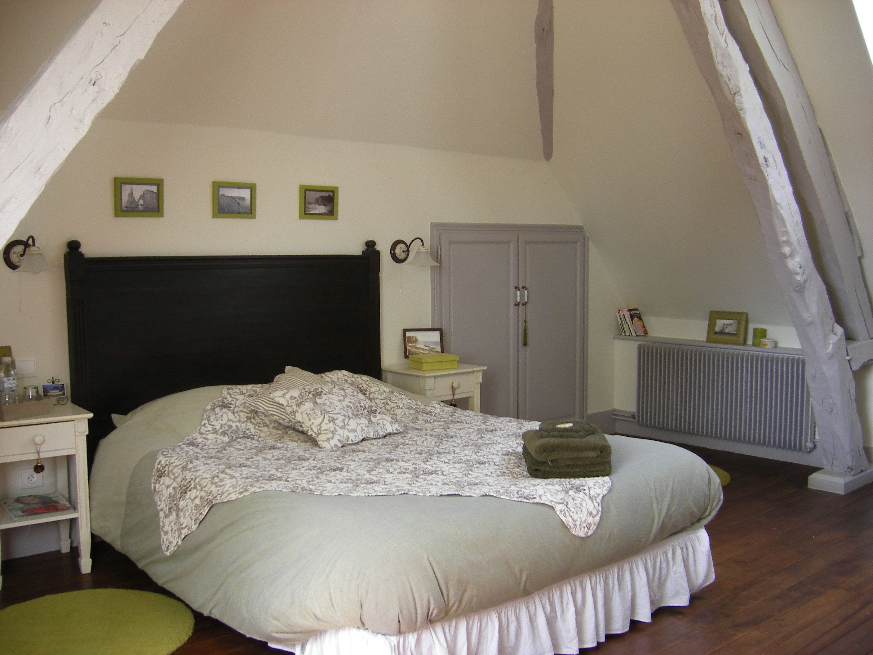 Une chambre à coucher avec un grand lit, une table de chevet, une commode et une armoire.