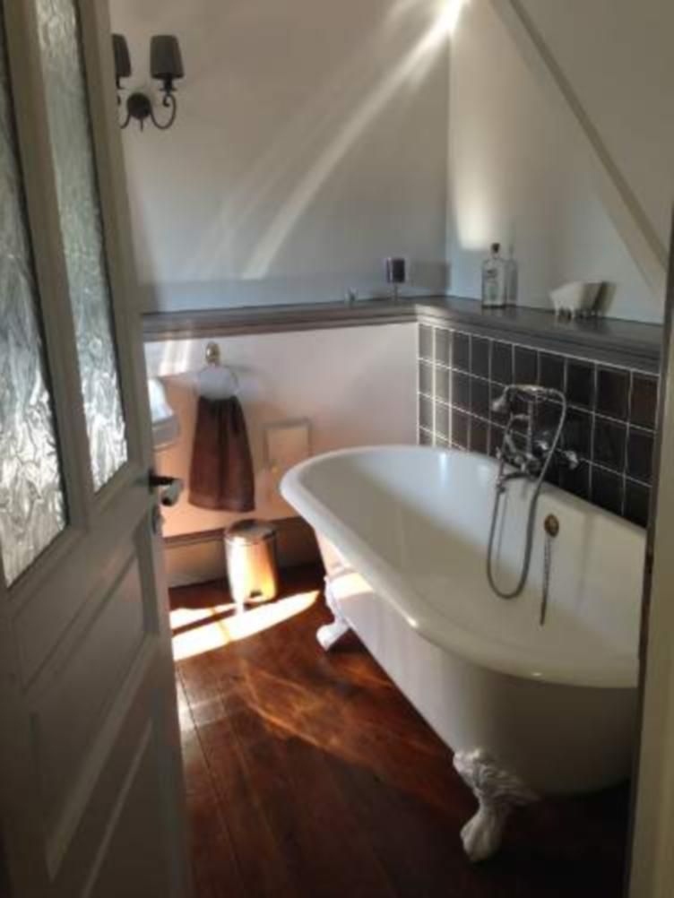 A bathroom with a freestanding bathtub, a towel rack, and a mirror.
