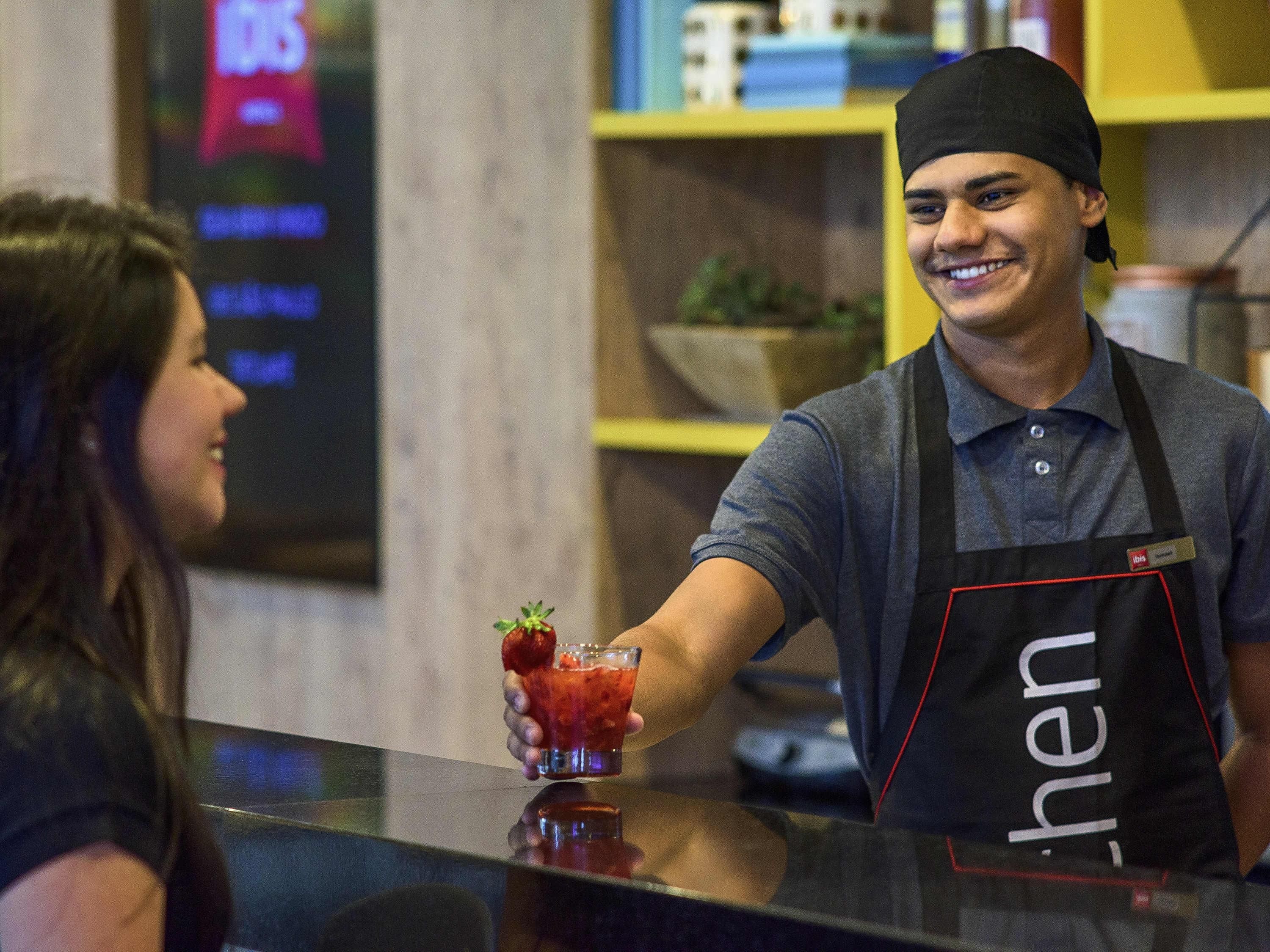 Un bar con un cantinero sirviendo una bebida a un cliente.