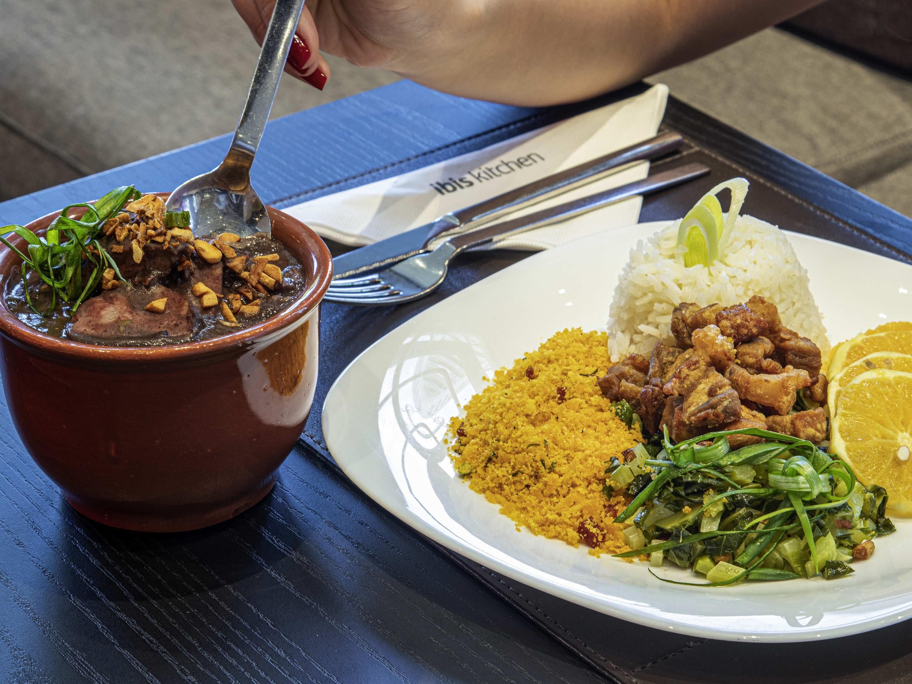 A plate of food with rice, meat, and vegetables, and a bowl of soup.