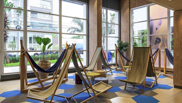 Una habitación con ventanas amplias, hamacas y vistas al exterior.
