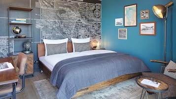 A bedroom with a bed, a desk, a chair, a globe, and a map on the wall.