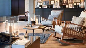 A modern living room with a wooden rocking chair, a round coffee table, and a fireplace. - Lighthouse Hotel & SPA (Büsum)