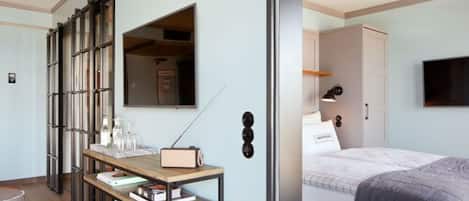 Et moderne hotelværelse med seng, sengebord og et stort spejl.