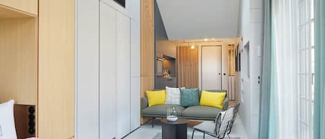 Een moderne slaapkamer met een bed, een bank en een klein tafeltje.