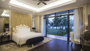 A modern bedroom with a large bed, a ceiling fan, and a view of the outdoors.
