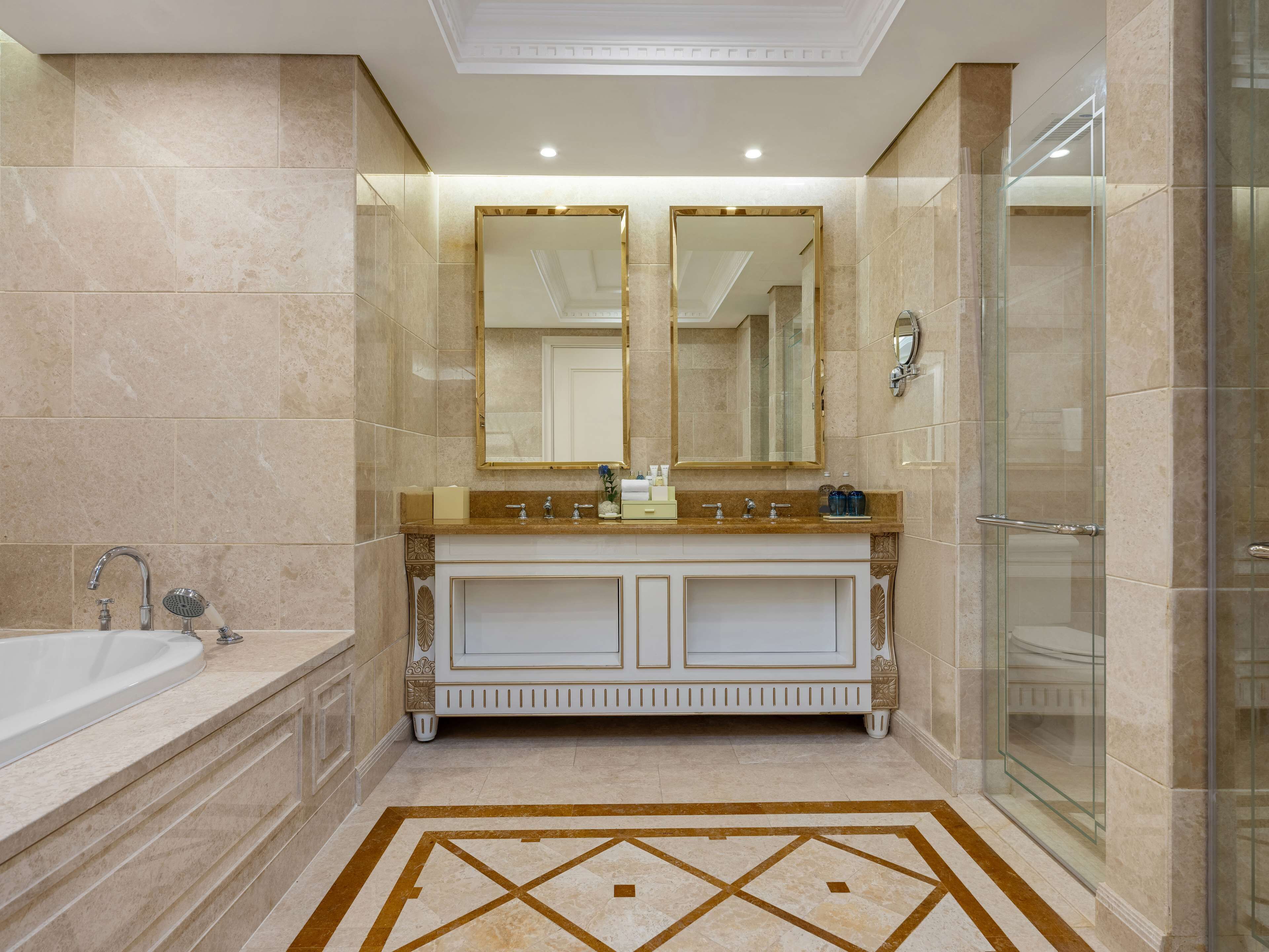 Un baño moderno con tocador doble, bañera y ducha con mampara de vidrio.