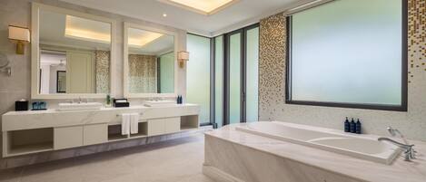 Une salle de bain moderne avec une grande baignoire, un meuble-lavabo à deux vasques et un grand miroir.