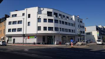 Ein modernes Gebäude mit flacher Fassade, zahlreichen Fenstern und einem Eingang im Erdgeschoss.