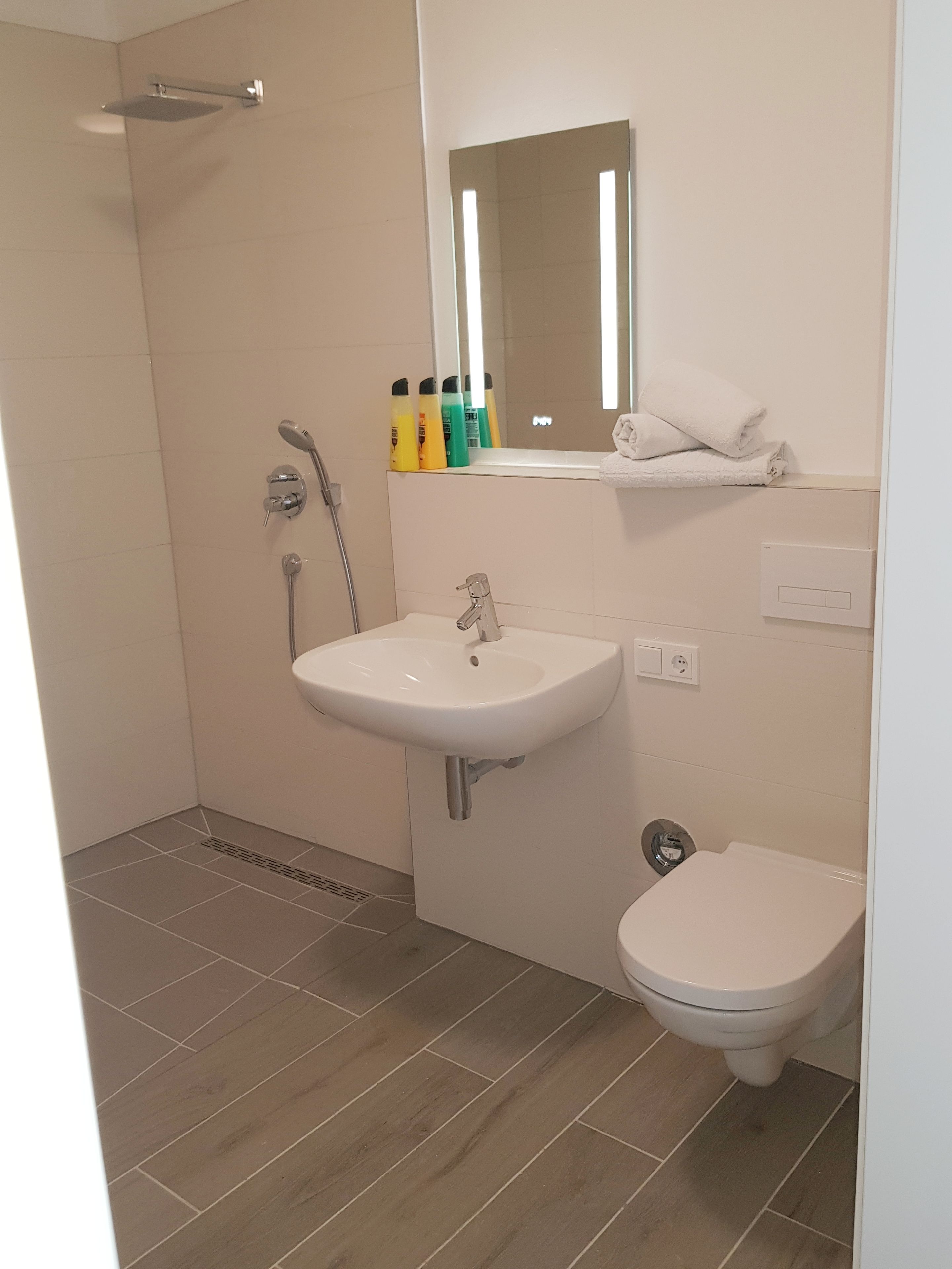 Ein Badezimmer mit Dusche, Waschbecken und Toilette.