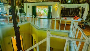 A multi-level wooden structure with a balcony, a thatched roof, and a view of the outdoors. - Upani in Daini (Diani Beach)