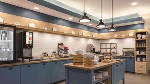 Una cocina moderna con armarios azules, una isla central y una cafetera.