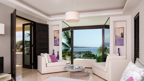 A modern living room with a large glass door leading to a balcony, white sofas, a coffee table, and a view of the sea. - Hacienda de Mita 506 by Tripwix (Punta de Mita)