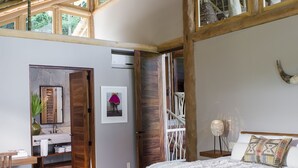 A spacious bedroom with a large bed, wooden flooring, and a ceiling fan. - Treehouse Punta Sayulita by Tripwix (Sayulita)