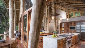 A spacious kitchen with a large island, wooden cabinetry, and a built-in oven. - Treehouse Punta Sayulita by Tripwix (Sayulita)