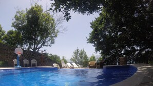 Alberca al aire libre y camastros