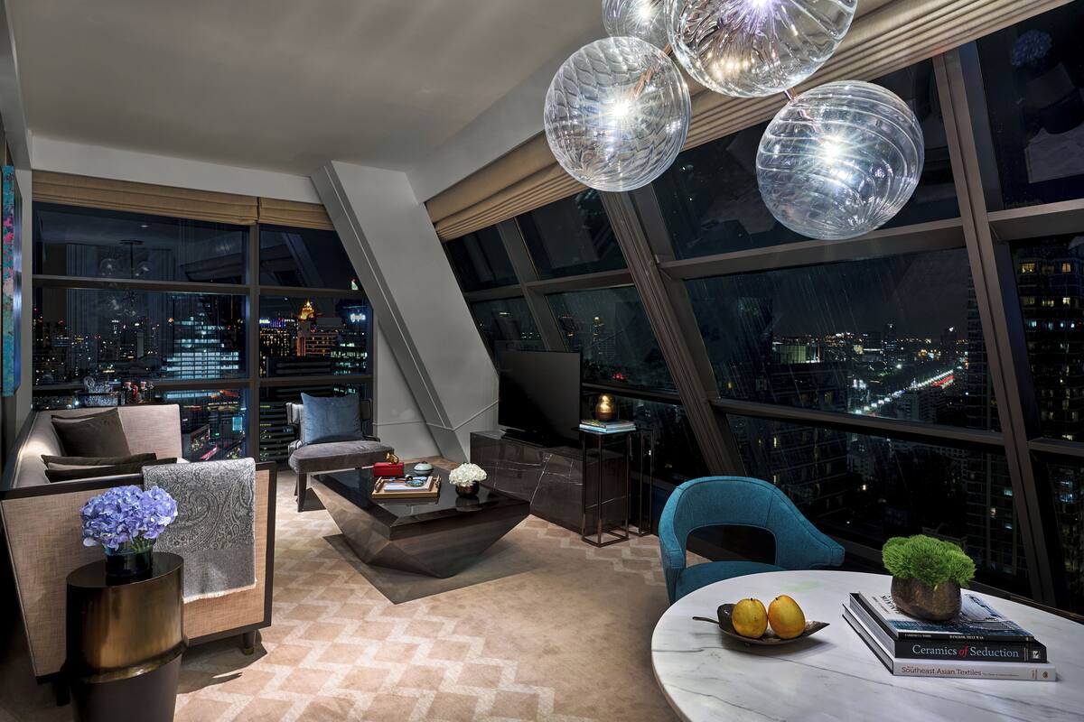 Una sala moderna con vistas a la ciudad, un ventanal grande y muebles contemporáneos.