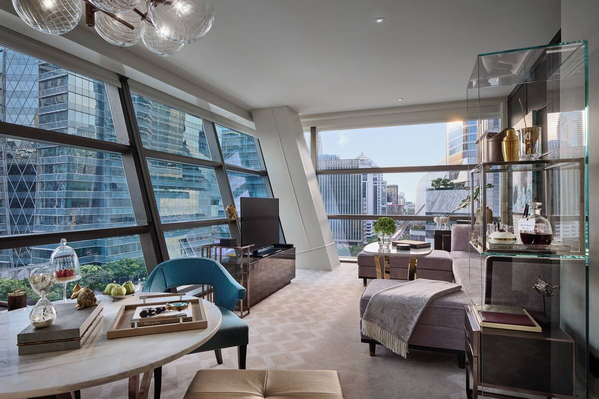 Un salón moderno con ventanas amplias, un aparador de vidrio y vistas a la ciudad.