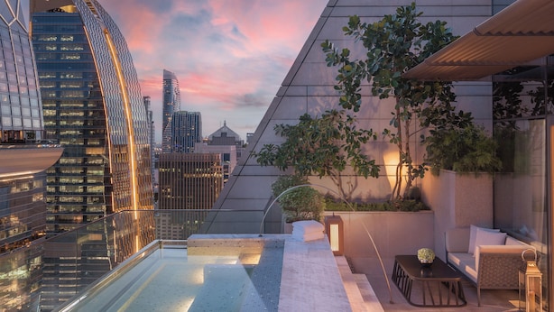 Eine Dachterrasse mit Pool, Sitzgelegenheit und Blick auf umliegende Wolkenkratzer.