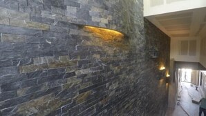 Eine Treppe mit einer Steinsäule an der Seite, die zu einem Zwischenpodest mit einer Lampe führt.