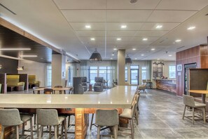 A spacious indoor area with a long bar, multiple seating arrangements, and a counter with a menu. - Courtyard by Marriott Fargo (Fargo)