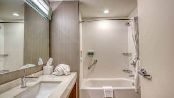 Un baño moderno con lavamanos, espejo y bañera.