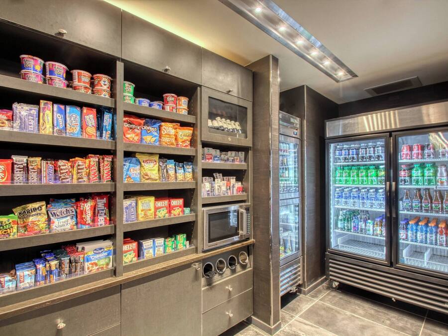 Zona de venta automática con aperitivos y bebidas, incluyendo diversas opciones de bocadillos y refrigerios.