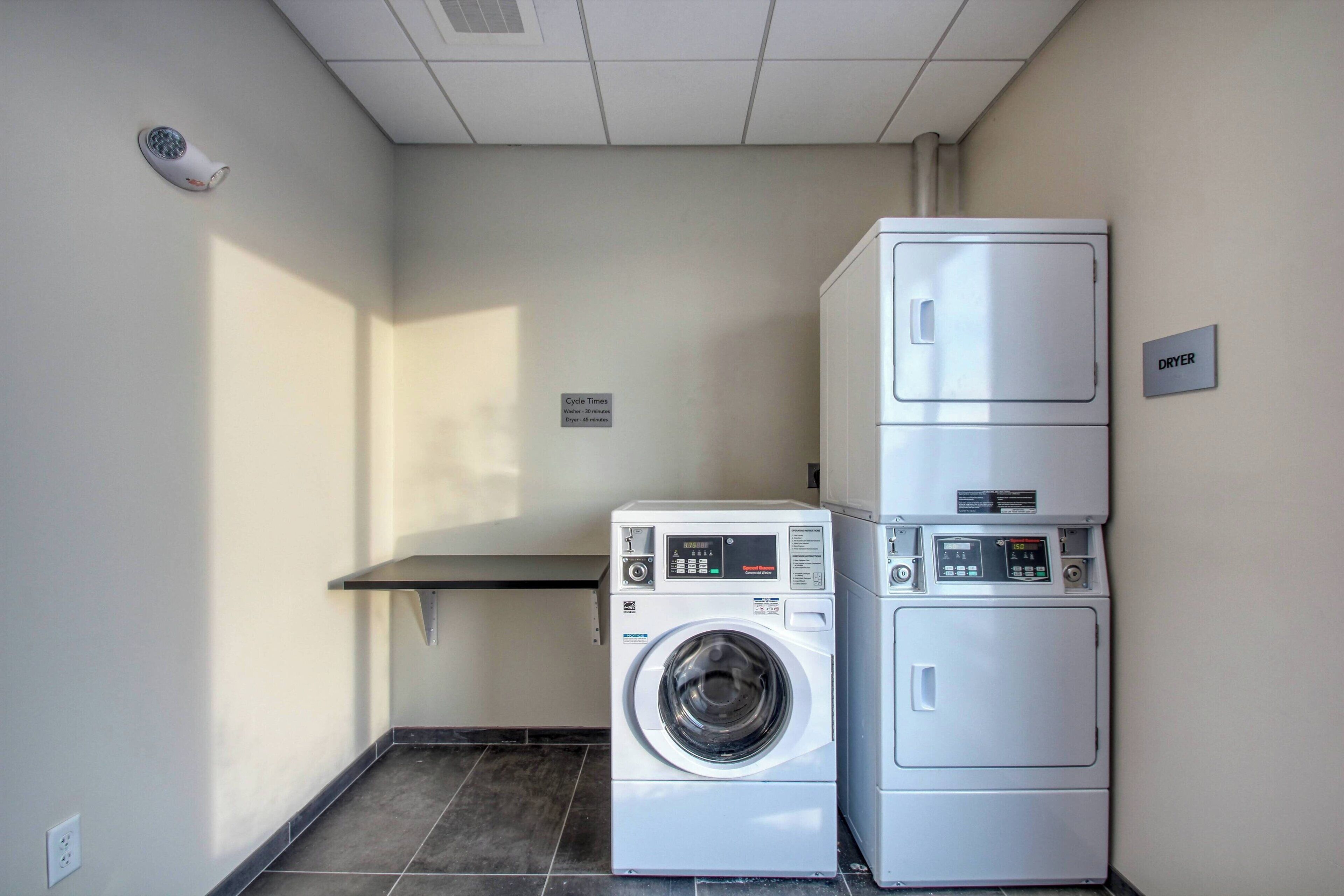 Un cuarto de lavandería con una lavadora y una secadora apiladas.