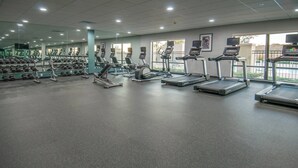Un gimnasio con cintas de correr, elípticas y pesas sueltas.