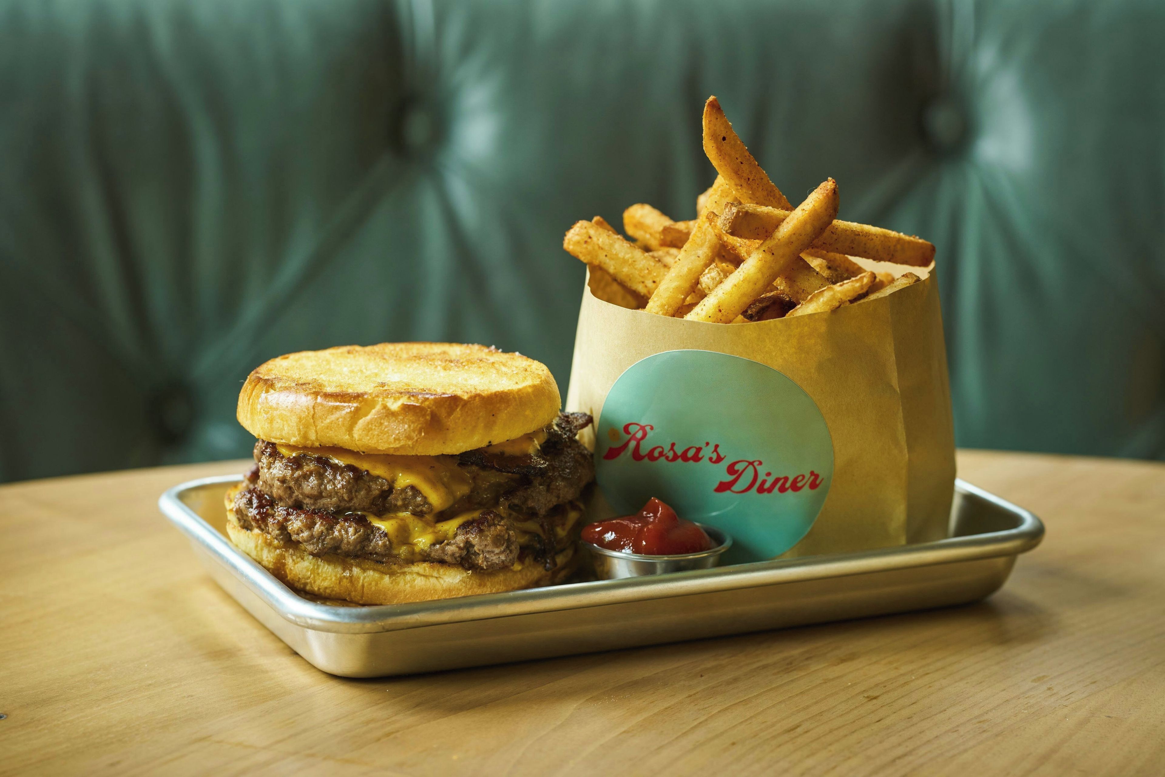 A meal consisting of a burger and fries served on a metal tray.