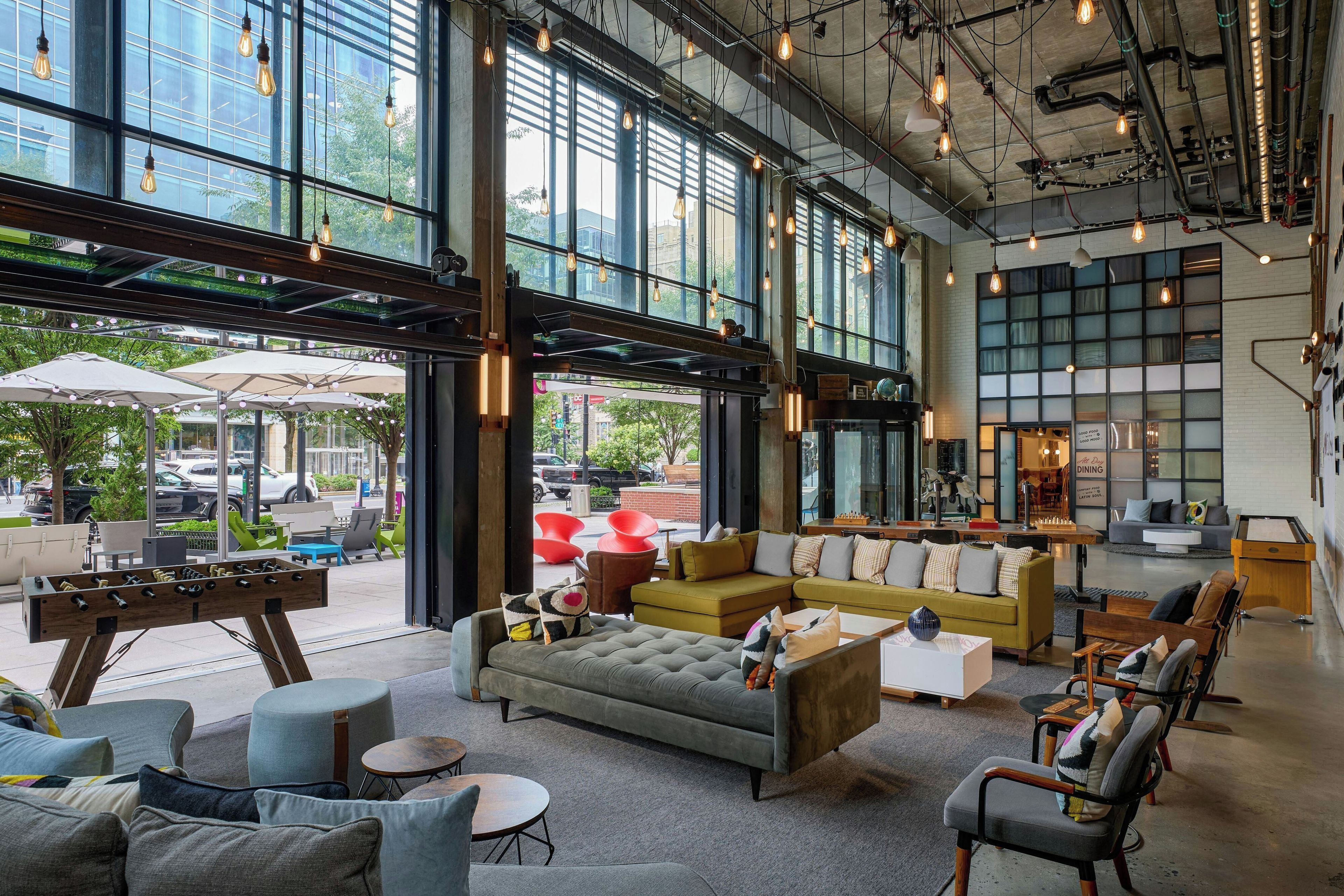 A spacious indoor area with large windows, a pool table, and comfortable seating.