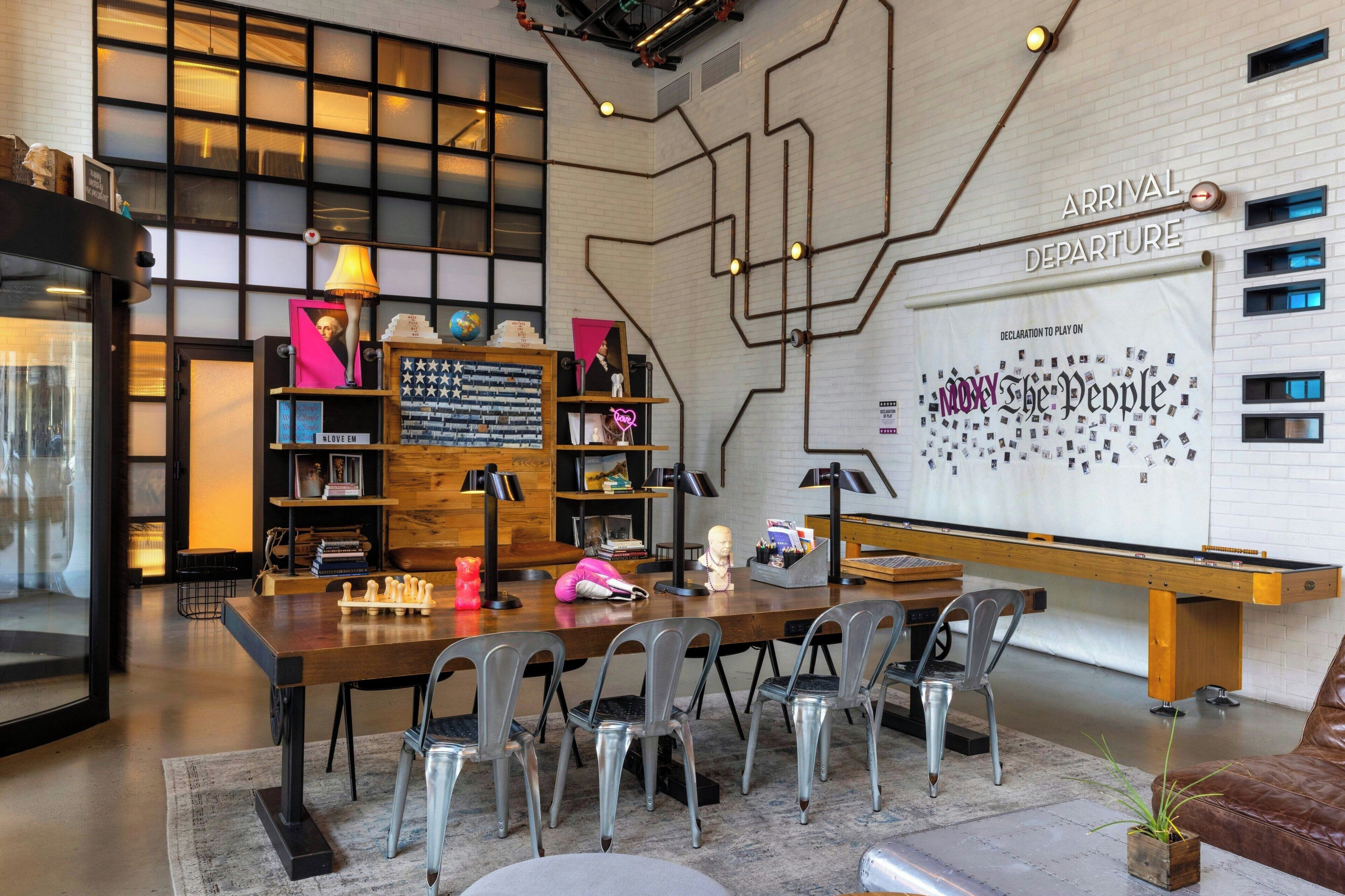 A modern interior with a long table, chairs, and a whiteboard with 'Arrival Departure' text.
