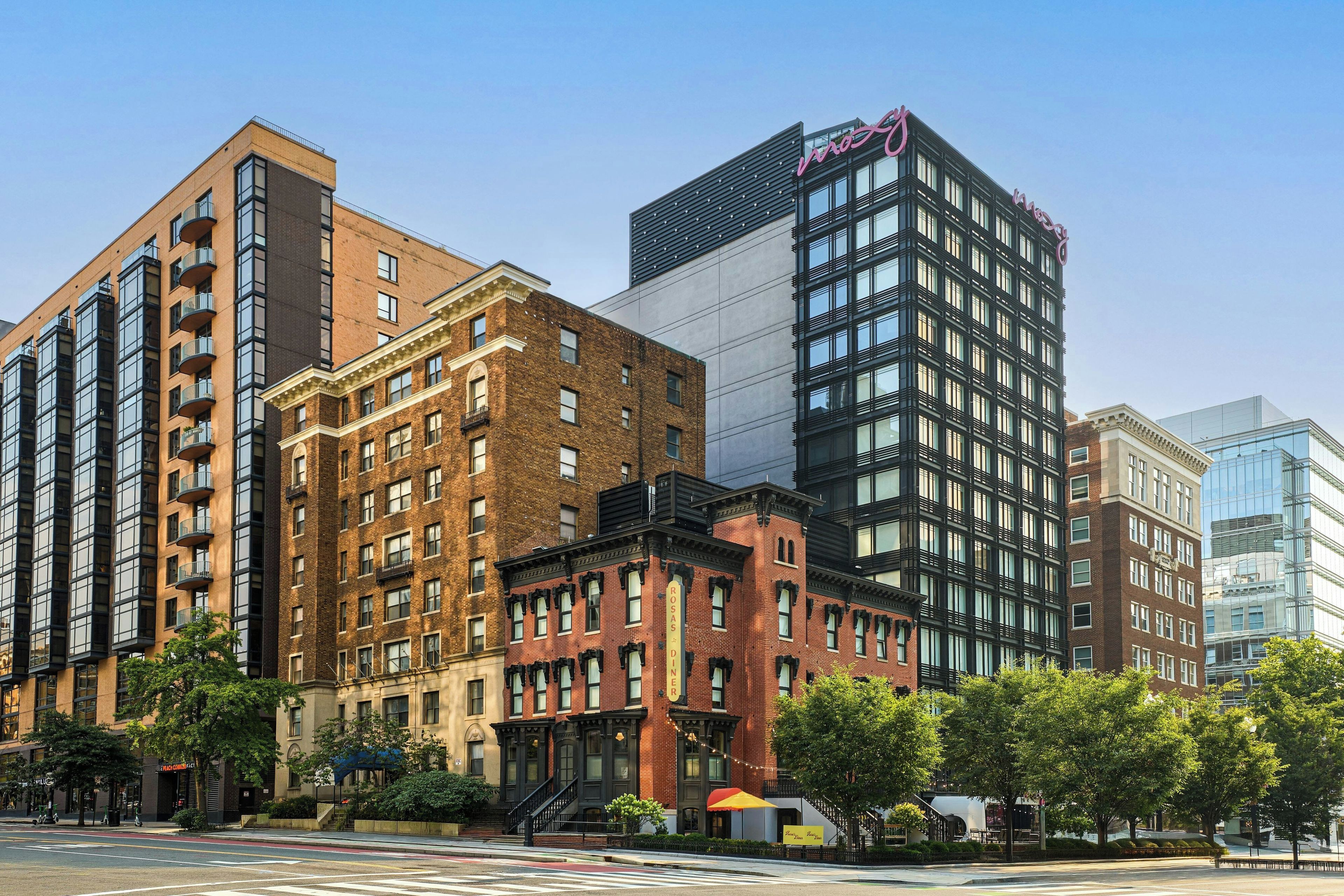 A multi-story building with a mix of brick and modern glass facades, featuring a prominent 'W' logo on the top.