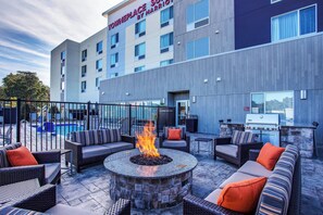 A hotel patio with outdoor seating, a fire pit, and a barbecue grill. - TownePlace Suites by Marriott Knoxville Oak Ridge (Oak Ridge)