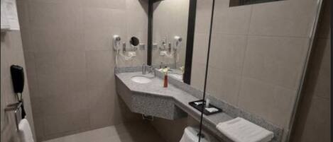 Un baño moderno con un inodoro, un lavamanos y un espejo.