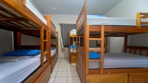 A dormitory room with bunk beds, a small desk, and a curtain. - Hostel Lençóis Park (Barreirinhas)