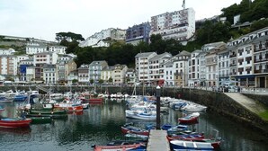 A marina with numerous boats docked along the pier, surrounded by residential buildings. - LA Nana DEL MAR Flat on the old Port of Cudillero (Cudillero)