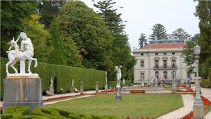 A formal garden with statues, manicured hedges, and a classical building in the background. - LA Nana DEL MAR Flat on the old Port of Cudillero (Cudillero)