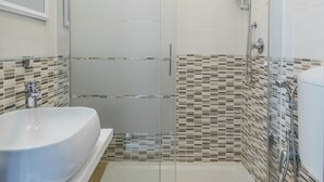 A modern bathroom with a glass-enclosed shower, a white sink, and a toilet. - Walker Rooms (Rome)