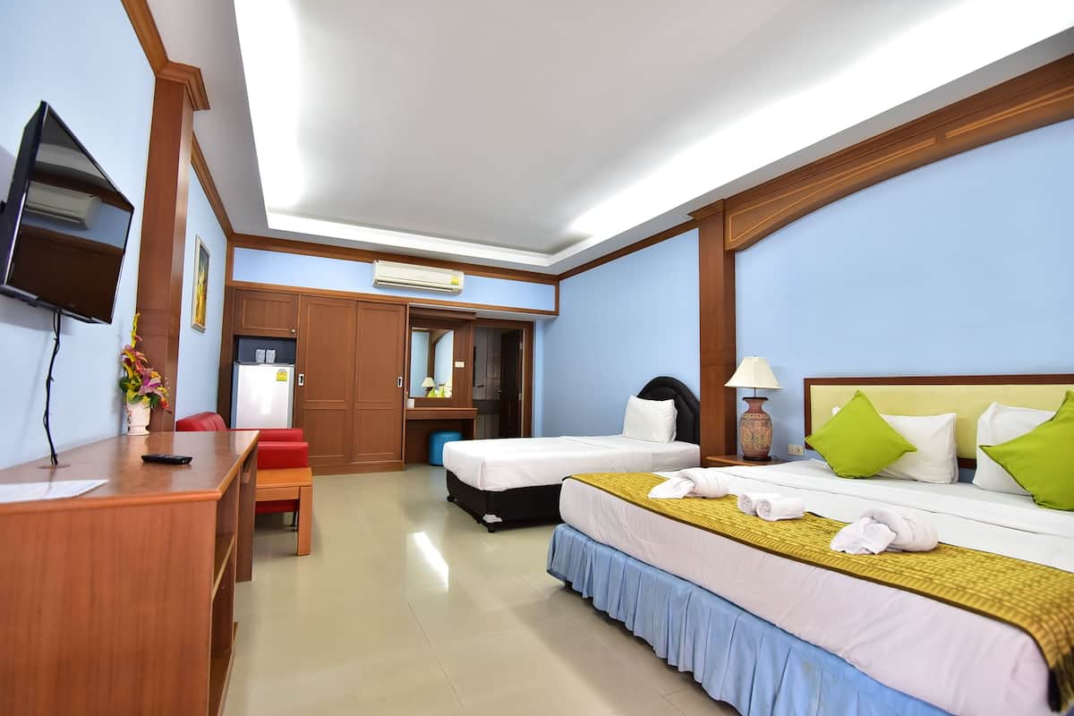 A hotel room with two beds, a desk, a TV, and a kitchenette.