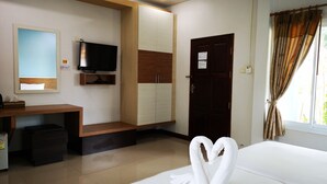 A hotel room with a bed, a TV, a desk, and a wardrobe. - Terra Villa Resort (Chok Chai)