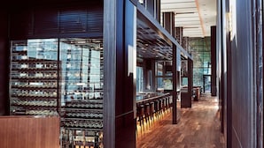 A modern interior with a wine rack, wooden flooring, and a long corridor with seating. - The Gate Hotel Tokyo By HULIC (Tokyo)