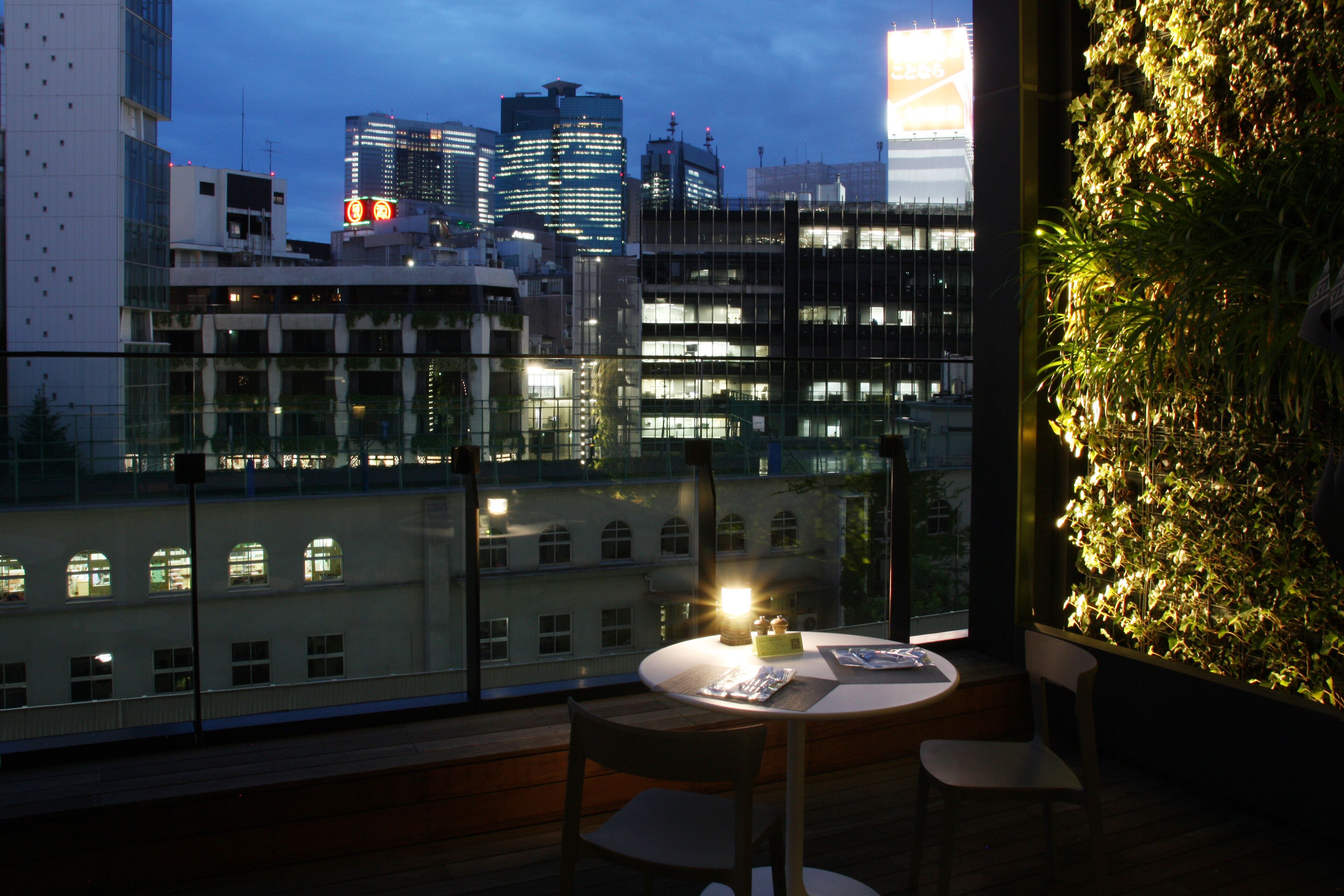 A modern dining area with a view of a city skyline at dusk.