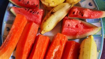 Un plato con frutas cortadas, como sandía, piña, plátano y papaya.