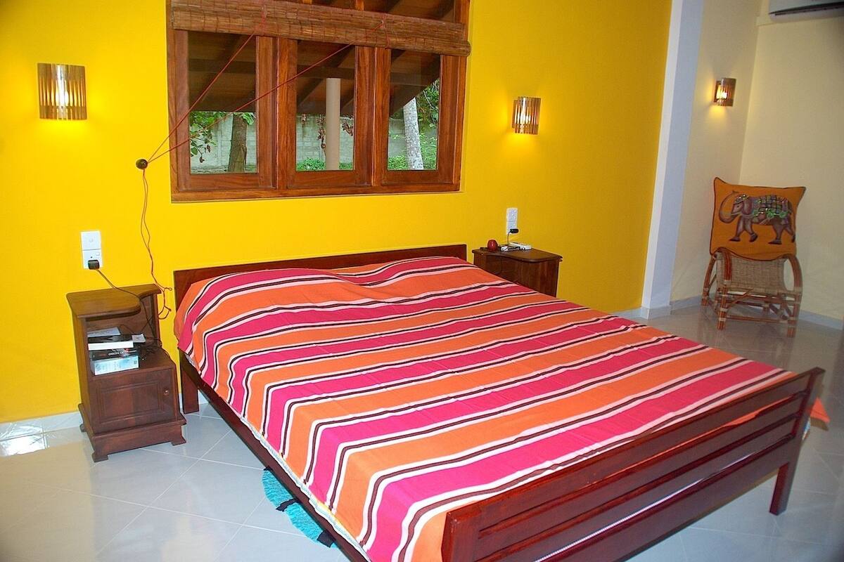 A bedroom with a bed, bedside tables, a window, and a chair.
