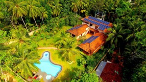 A tropical resort with multiple buildings, a swimming pool, and lush greenery. - King Coconut Lodge (Koggala)