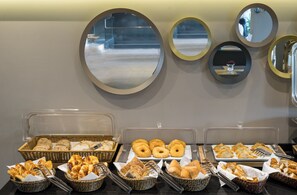 A breakfast buffet with various baked goods and pastries displayed in baskets and trays. - Upsuites Hotel (Istanbul)