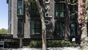 Een modern hotelgebouw met een bord waarop staat: UPS SUITES HOTEL.