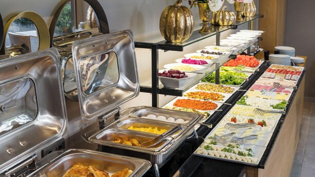 Een buffet met diverse gerechten en een decoratieve vaas.
