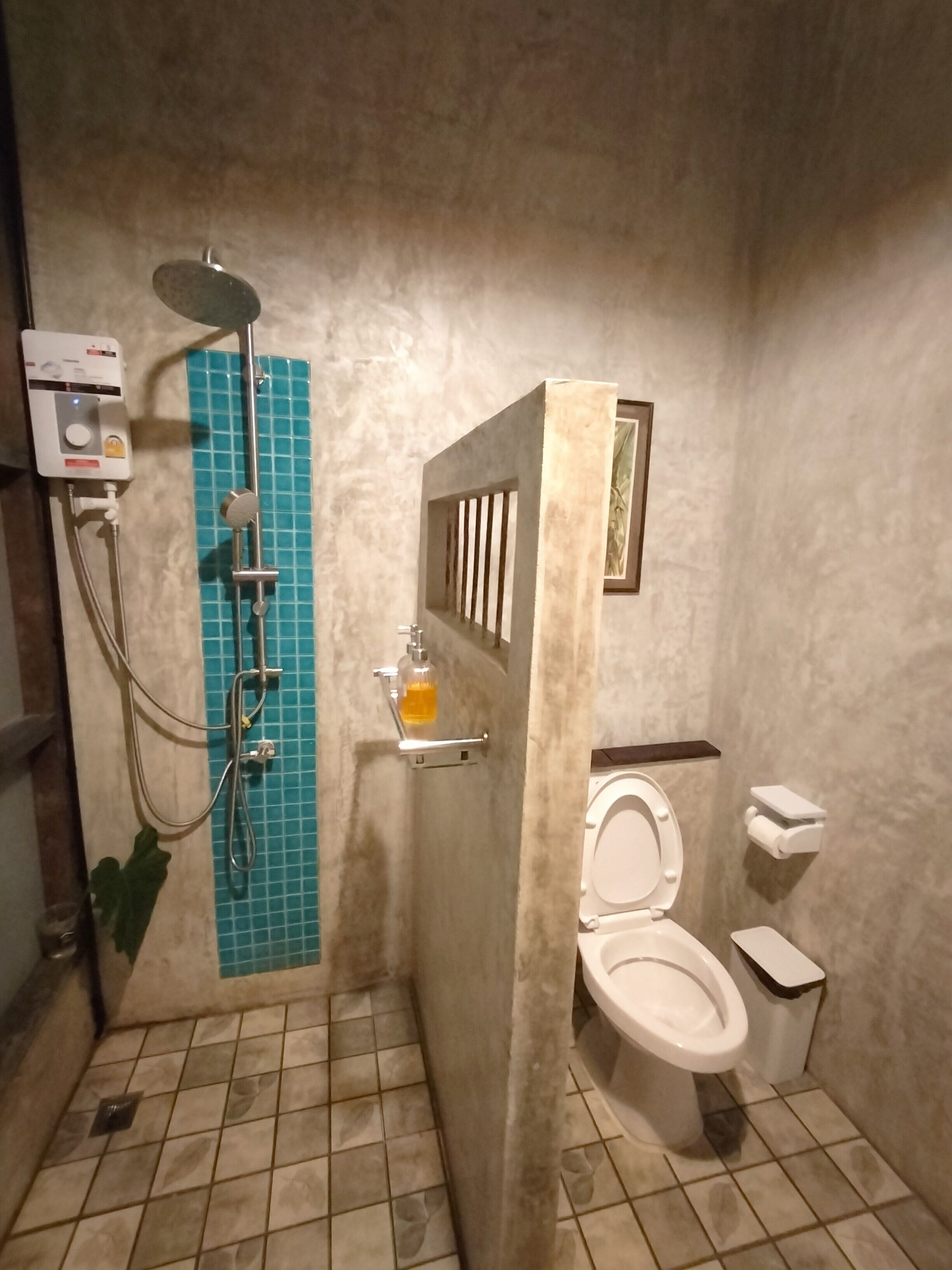 Un baño con ducha, inodoro y lavabo con dispensador de jabón.